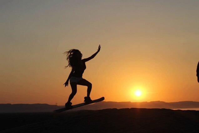 Group of tourists riding quad bikes through the golden sand dunes on an Agadir desert adventure tour